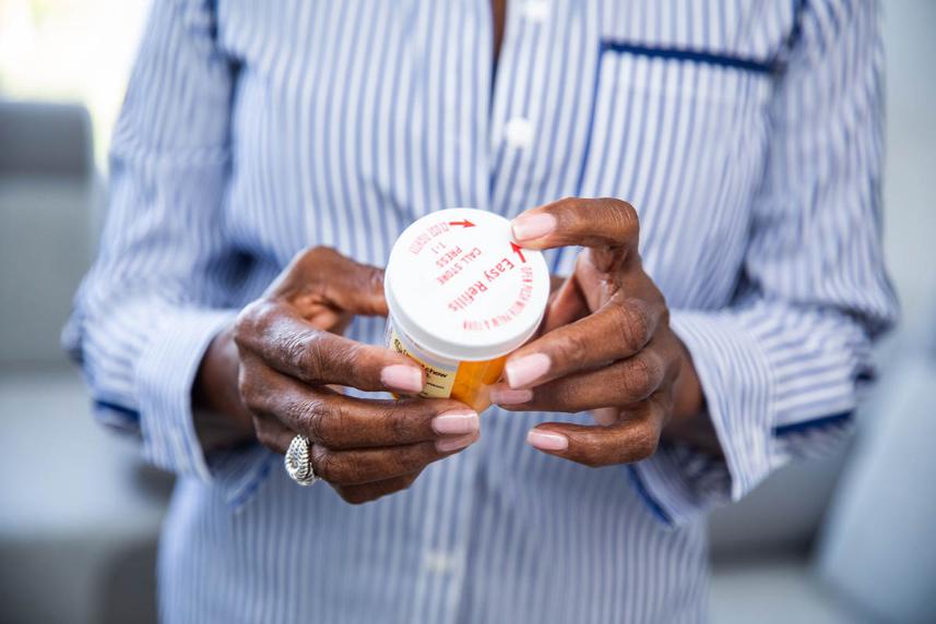 Woman holding medication and looking at label